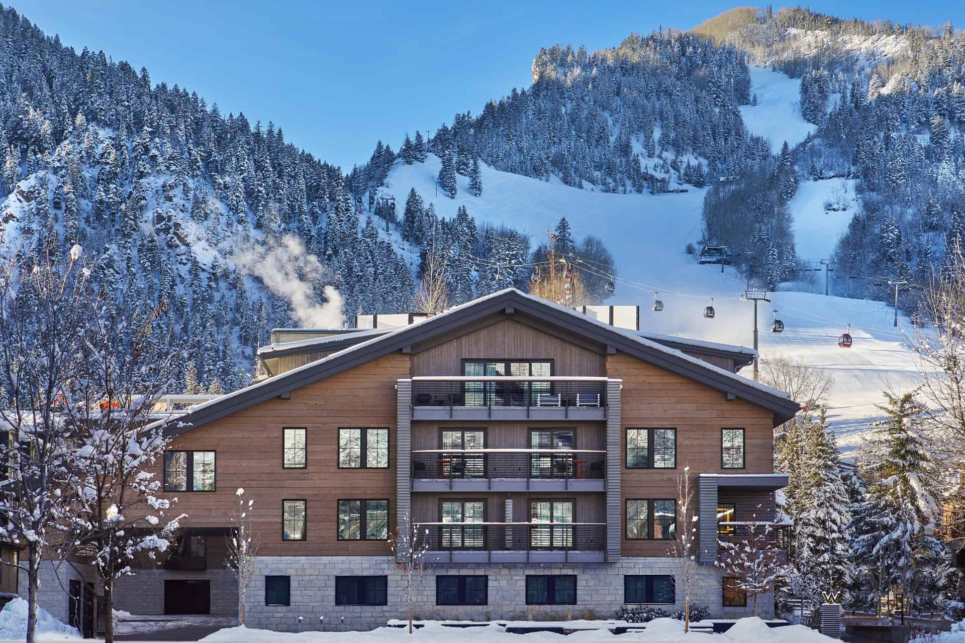 The Sky Residences at W Aspen overlooking snowy skiing mountains.